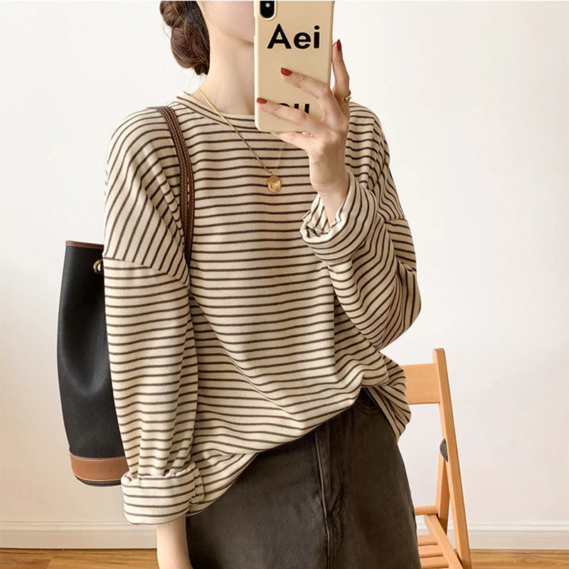 Model wearing a women's striped crewneck top, great for casual wear & effortless style.