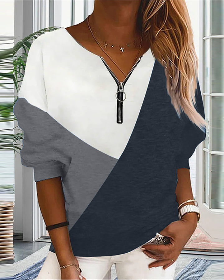 Modern women's V-neck color block sweatshirt with zip detail. Comfortable long-sleeve casual top.