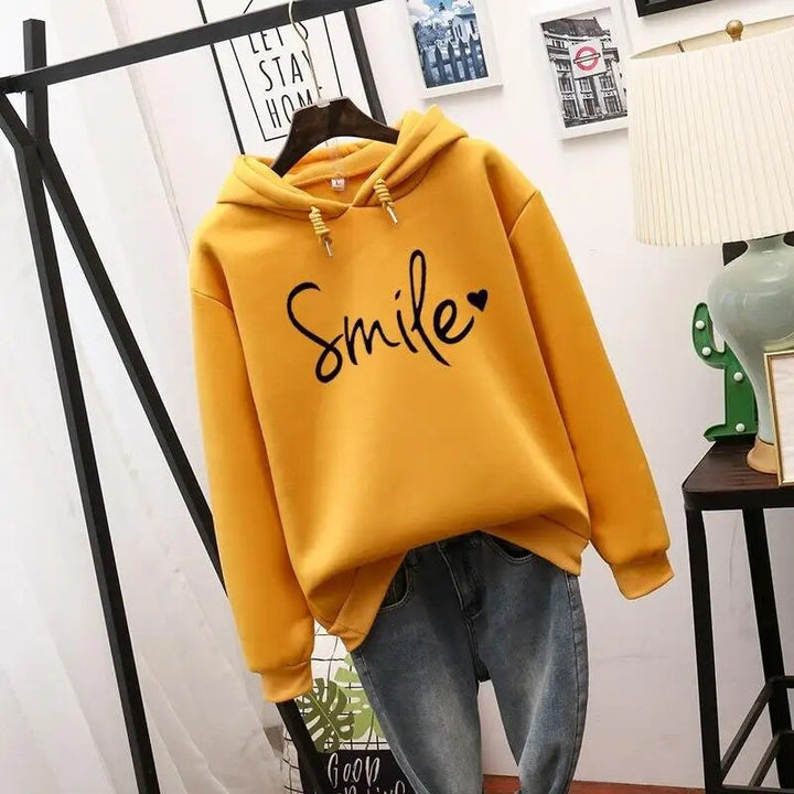 Relaxed fit women's hoodie with a soft fabric & cute smile graphic, ideal for everyday casual comfort.