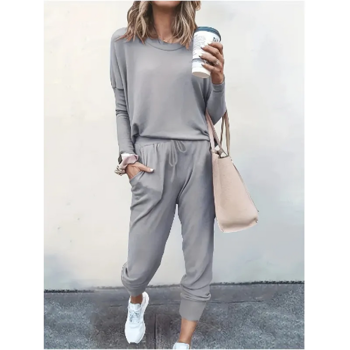 Woman wearing a comfortable crew neck jogger set, showcasing the long sleeve top and tapered pants for loungewear.