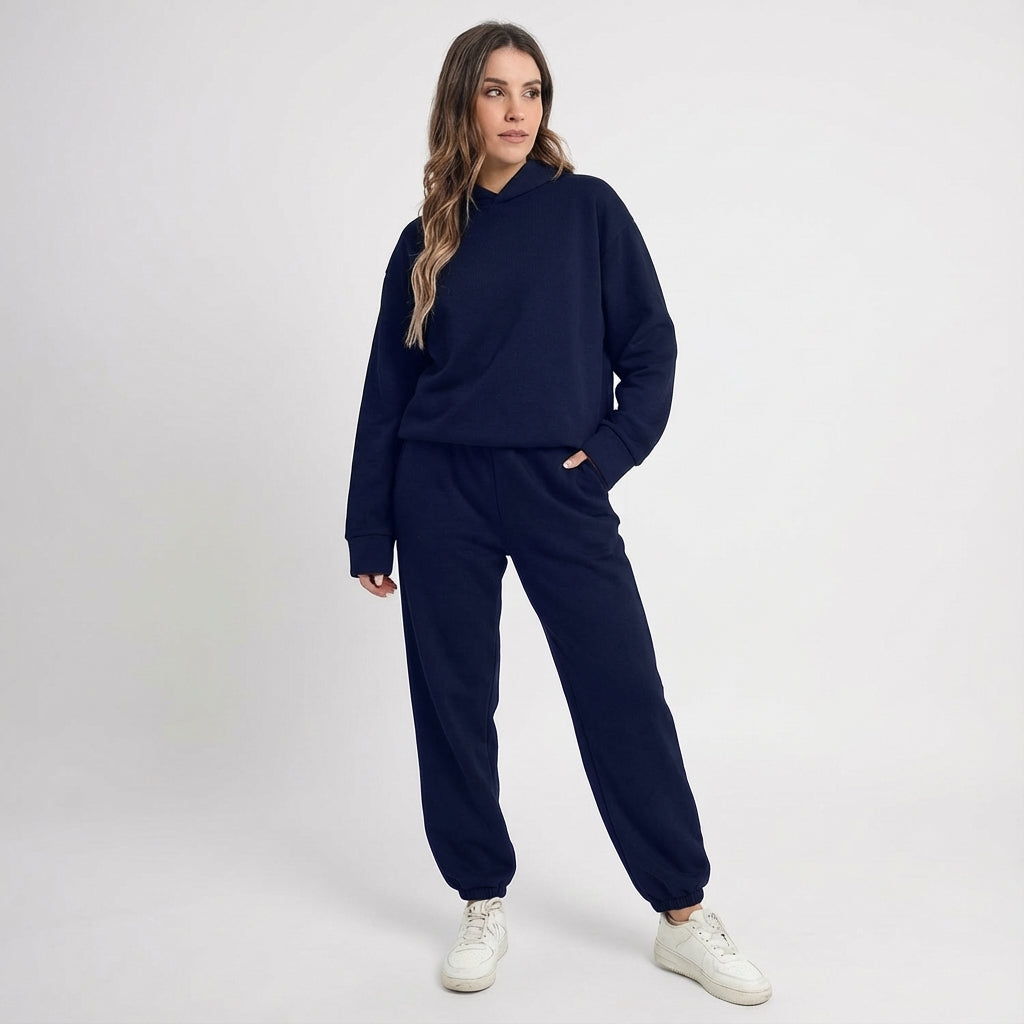 Side profile of a woman in a black all-season tracksuit, showcasing its flattering fit for sportswear