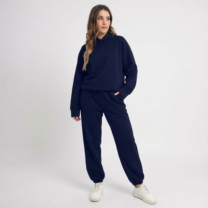 Side profile of a woman in a black all-season tracksuit, showcasing its flattering fit for sportswear