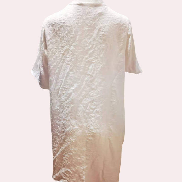 Woman wearing chic short button-down shirt dress, perfect for casual summer outings or vacation.