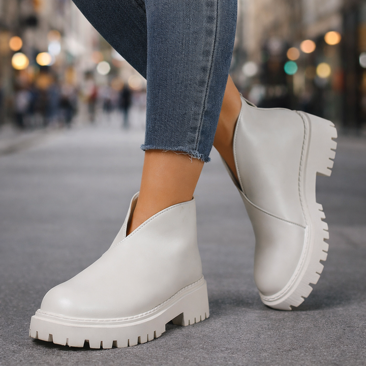 Fashionable white leather platform slip-on sandals for women, offering comfortable and casual style.