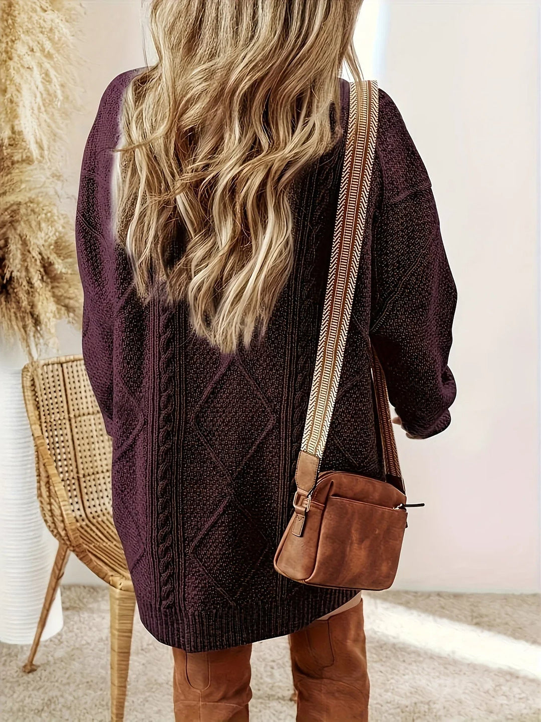 Fashionable women's oversized cable knit sweater dress, ideal for cozy fall outfits.