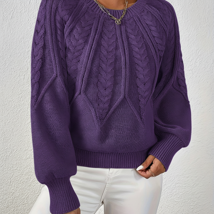 Detail of the voluminous lantern sleeve on a women's cable knit jumper, soft acrylic wool