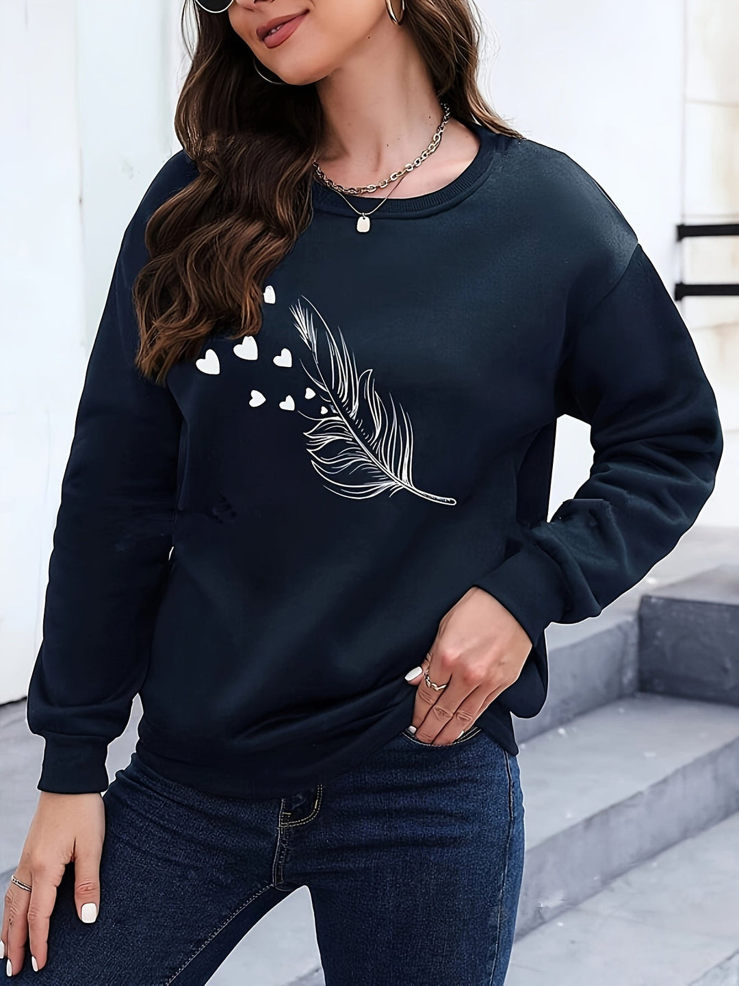 Stylish women's feather print casual sweatshirt. Soft long sleeve pullover for cozy autumn wear.