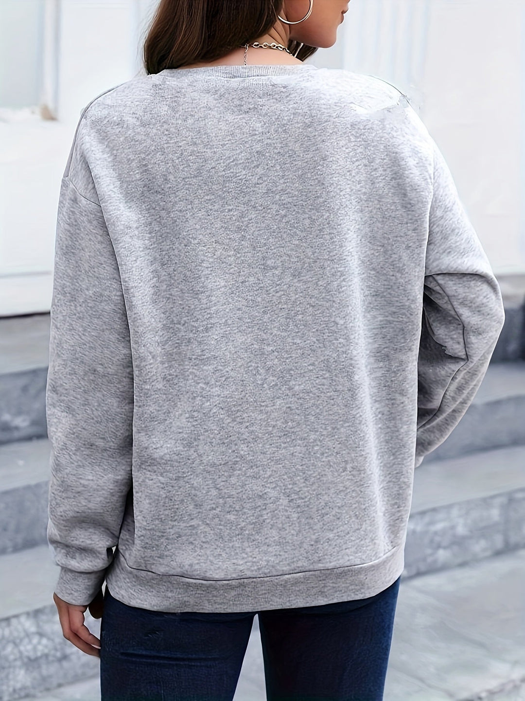 Cozy women's feather print long sleeve sweatshirt. Stylish pullover for casual winter outfits.