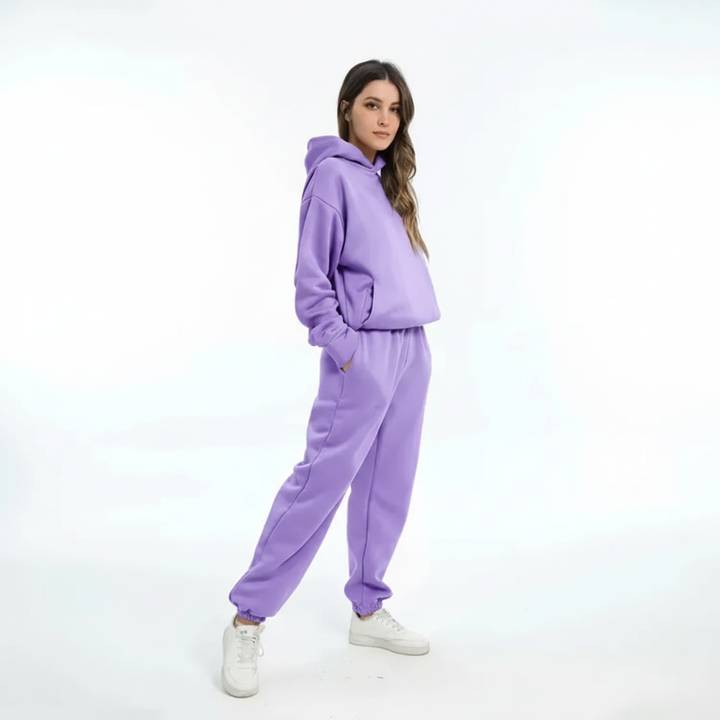 Woman wearing a comfortable fleece hoodie and jogger pants, showcasing the cozy fit.