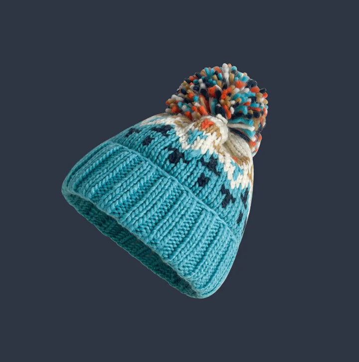 Comfortable women's knitted pom-pom beanie, perfect for winter with its snowflake pattern.