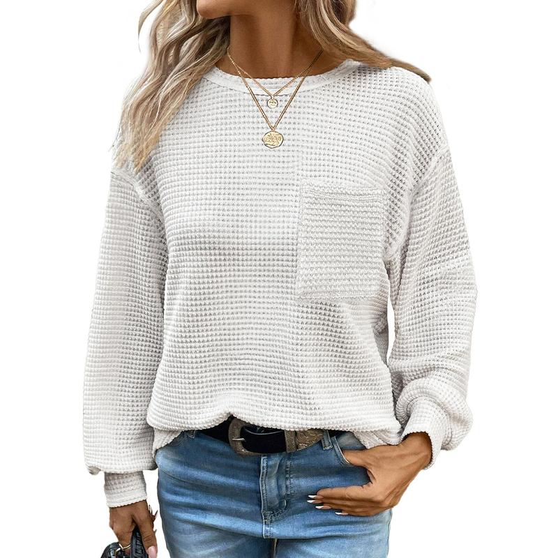 Close-up of the cozy knit fabric of a women's oversized long sleeve crewneck blouse, soft and warm.