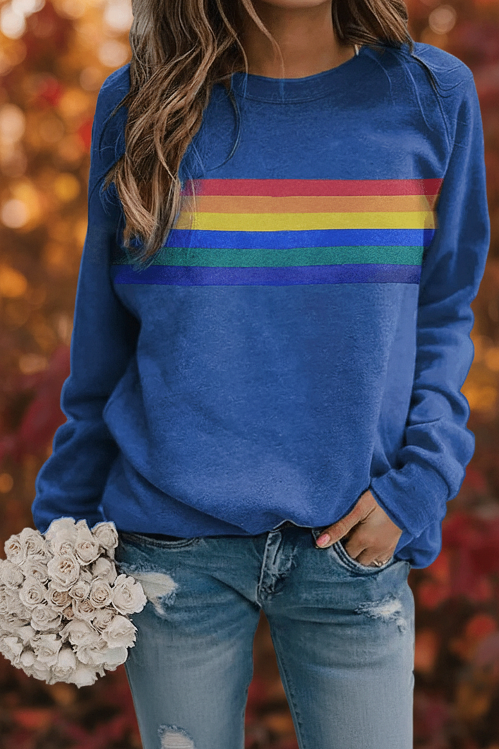 Woman wearing a cozy rainbow striped sweatshirt, a comfortable pullover top for casual and retro-style outfits.