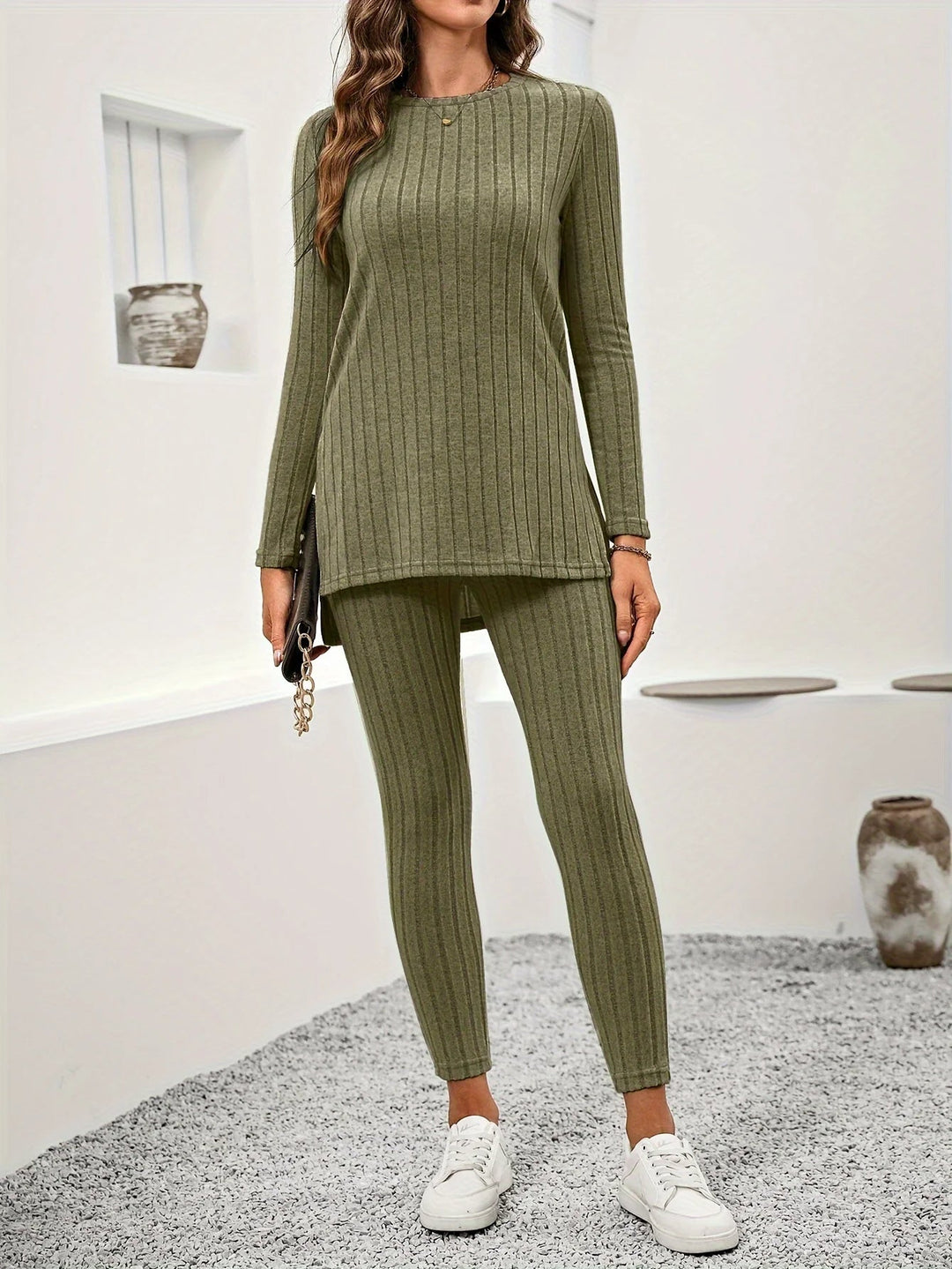 Woman in cozy ribbed knit lounge set, reading a book, embracing comfort and relaxation at home.