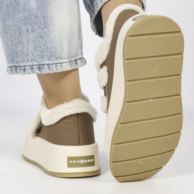 Women's warm slip-on winter shoes with cozy lining, comfortable fit, and stylish strap detail.