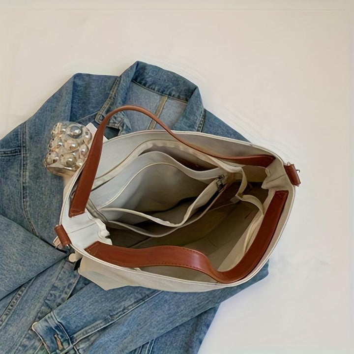 Women's versatile black canvas shoulder bag, durable and spacious for everyday essentials.
