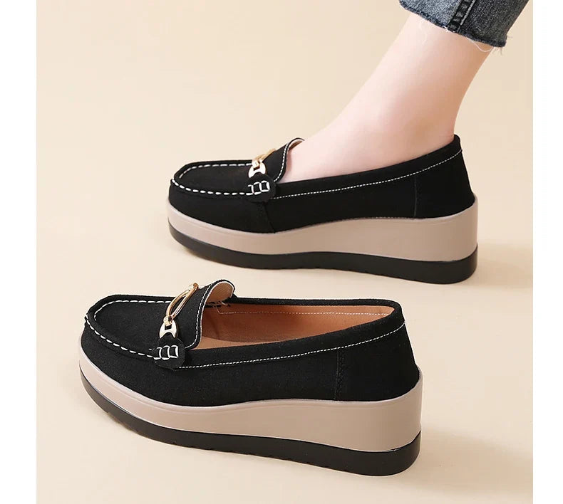 Close-up of women's cushioned loafers, showing textured upper & comfortable platform sole detail.