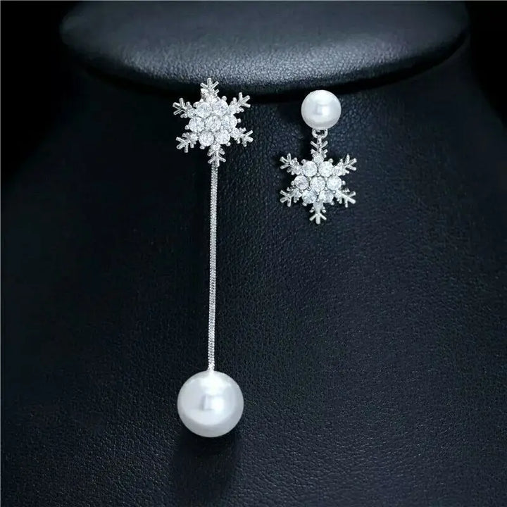 Model wearing dainty sterling silver snowflake drop earrings, enhancing her elegant winter fashion style.