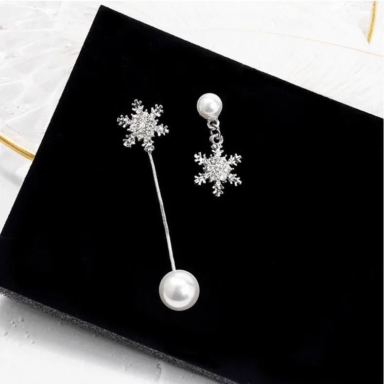 Sparkling sterling silver dainty snowflake drop earrings, a charming winter jewelry accessory for women.