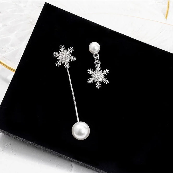 Sparkling sterling silver dainty snowflake drop earrings, a charming winter jewelry accessory for women.