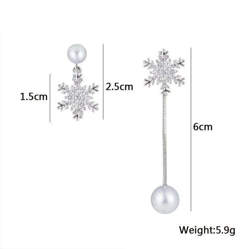 Pair of dainty sterling silver snowflake drop earrings displayed, elegant women's winter jewelry with festive appeal.