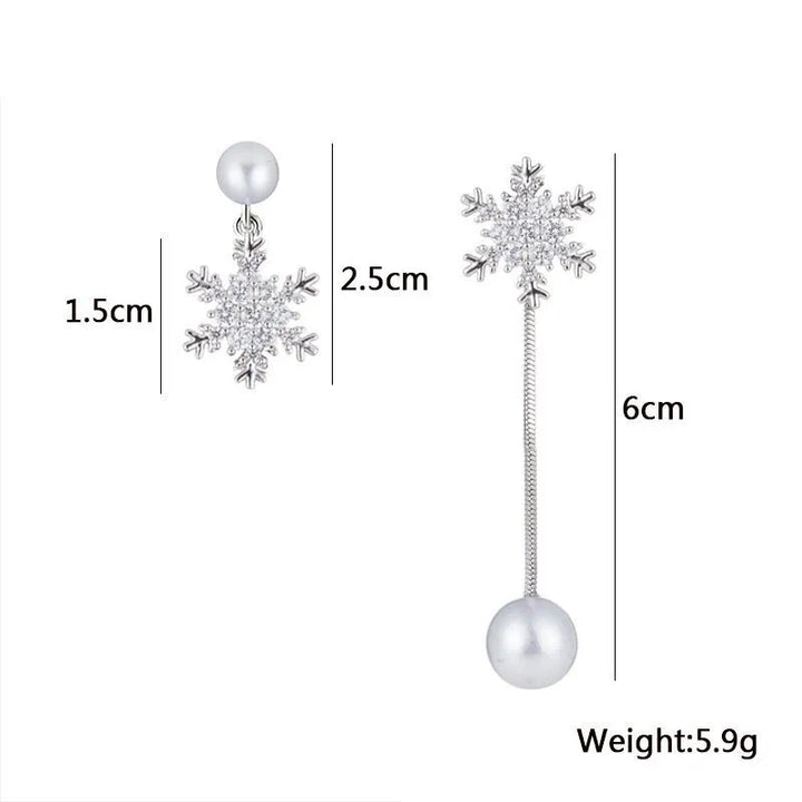 Pair of dainty sterling silver snowflake drop earrings displayed, elegant women's winter jewelry with festive appeal.