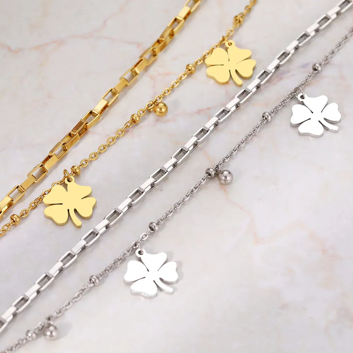 Close-up of a delicate gold & silver four-leaf clover bracelet, showcasing its intricate lucky charm design for women.