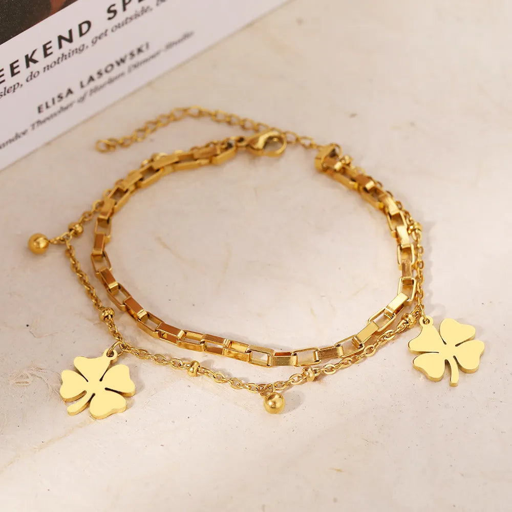 Stylish women's gold and silver four-leaf clover bracelet, a versatile lucky charm for everyday wear or special occasions.
