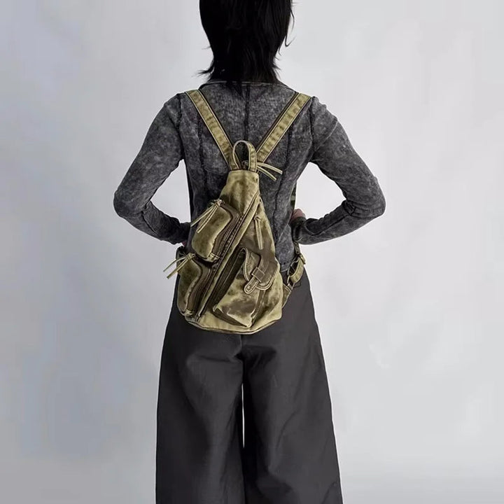 Women's versatile distressed backpack. Converts effortlessly to a sling or chest bag. Fashionable travel accessory.