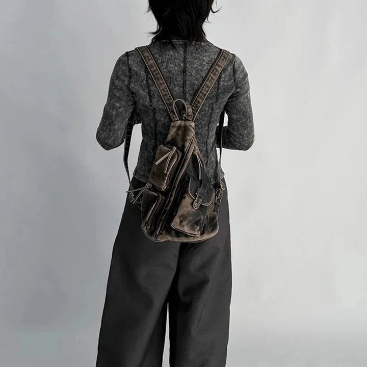Versatile women's fashion backpack. Distressed design, converts to sling or chest bag. Perfect travel accessory.