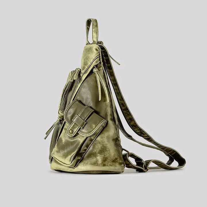 Chic women's distressed backpack, easily converts to a sling or chest bag. A versatile fashion travel accessory.
