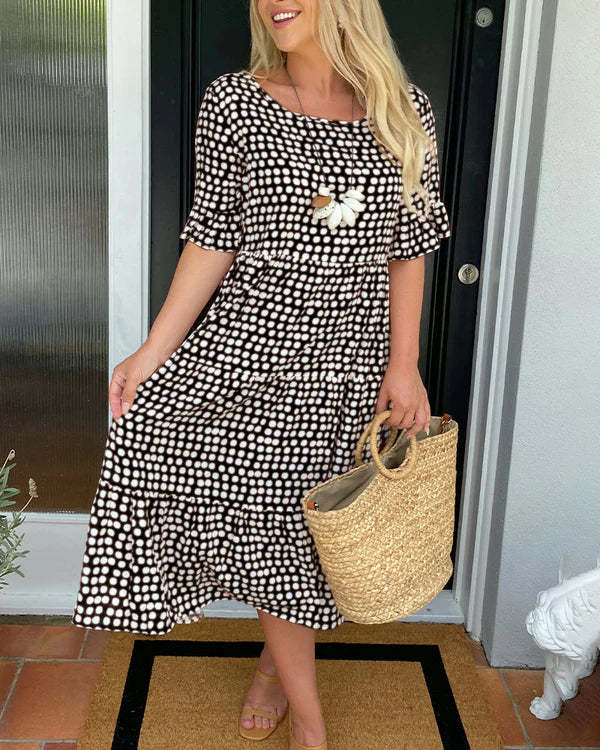 Dotted midi dress for women, featuring a relaxed fit, short sleeves, and comfortable fabric. Casual elegance.