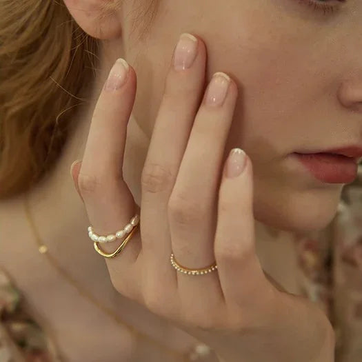 Women's double layered gold ring featuring a lustrous freshwater pearl. Elegant and stylish fashion accessory.
