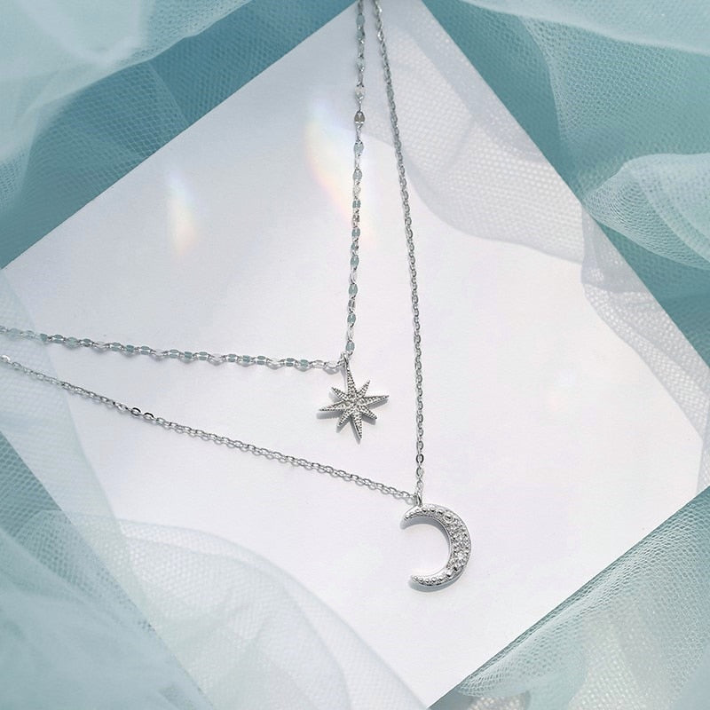 Close-up of a women's double moon sterling silver layered necklace, showcasing its fine details and celestial charm.