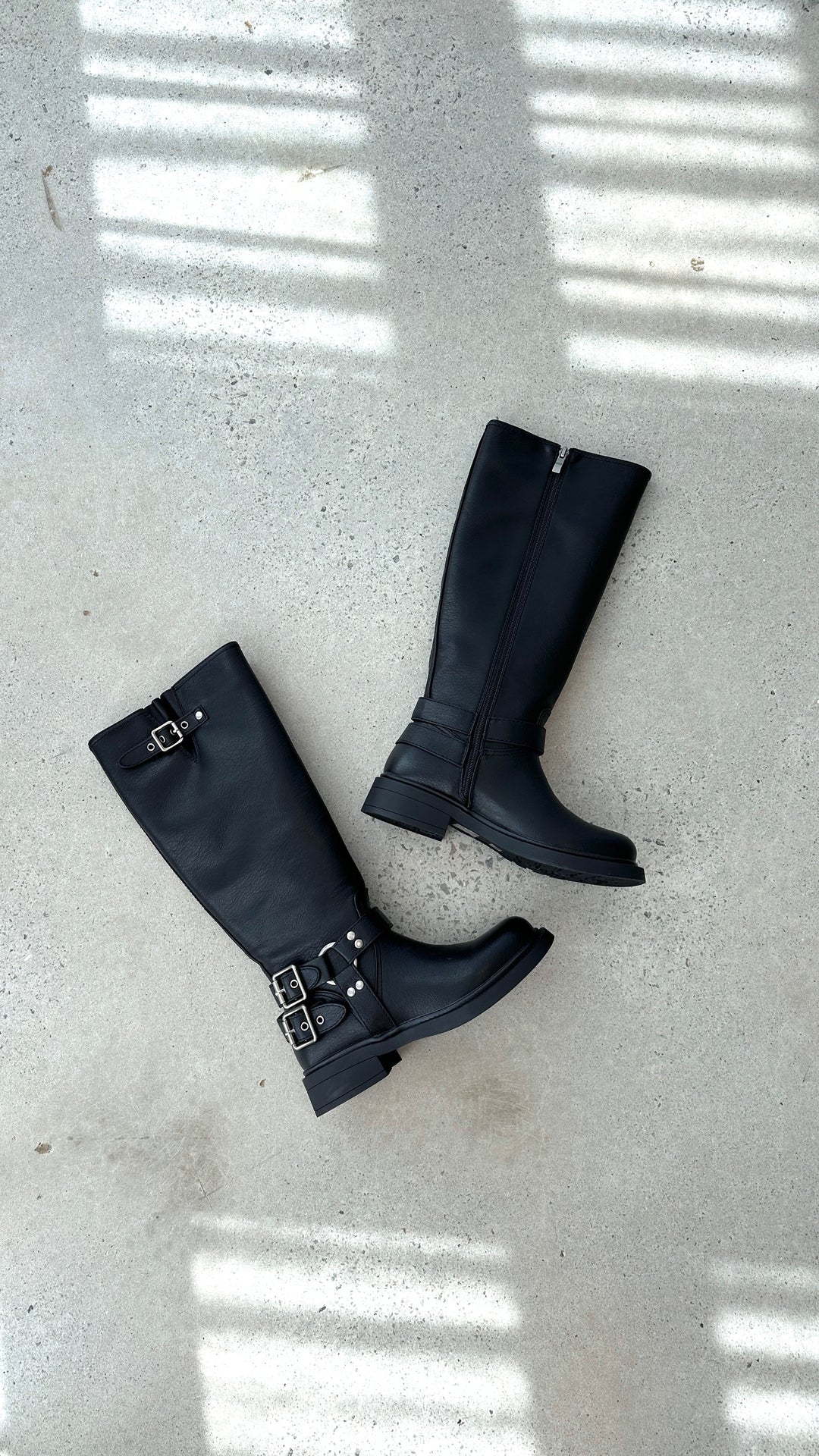 Aris women's black buckle combat boots, offering an edgy punk style and sturdy design for fall & winter.