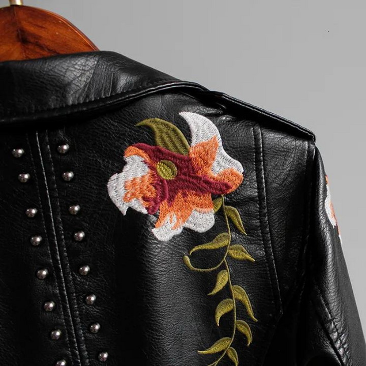 Asymmetrical zipper & notched collar on a chic women's edgy floral embroidered studded jacket.
