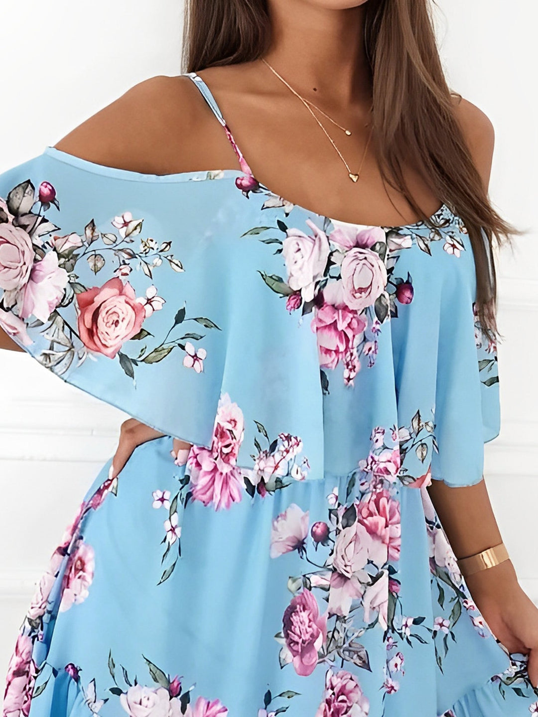 Close-up of the light fabric and elegant floral print of this women's cold shoulder mini dress.