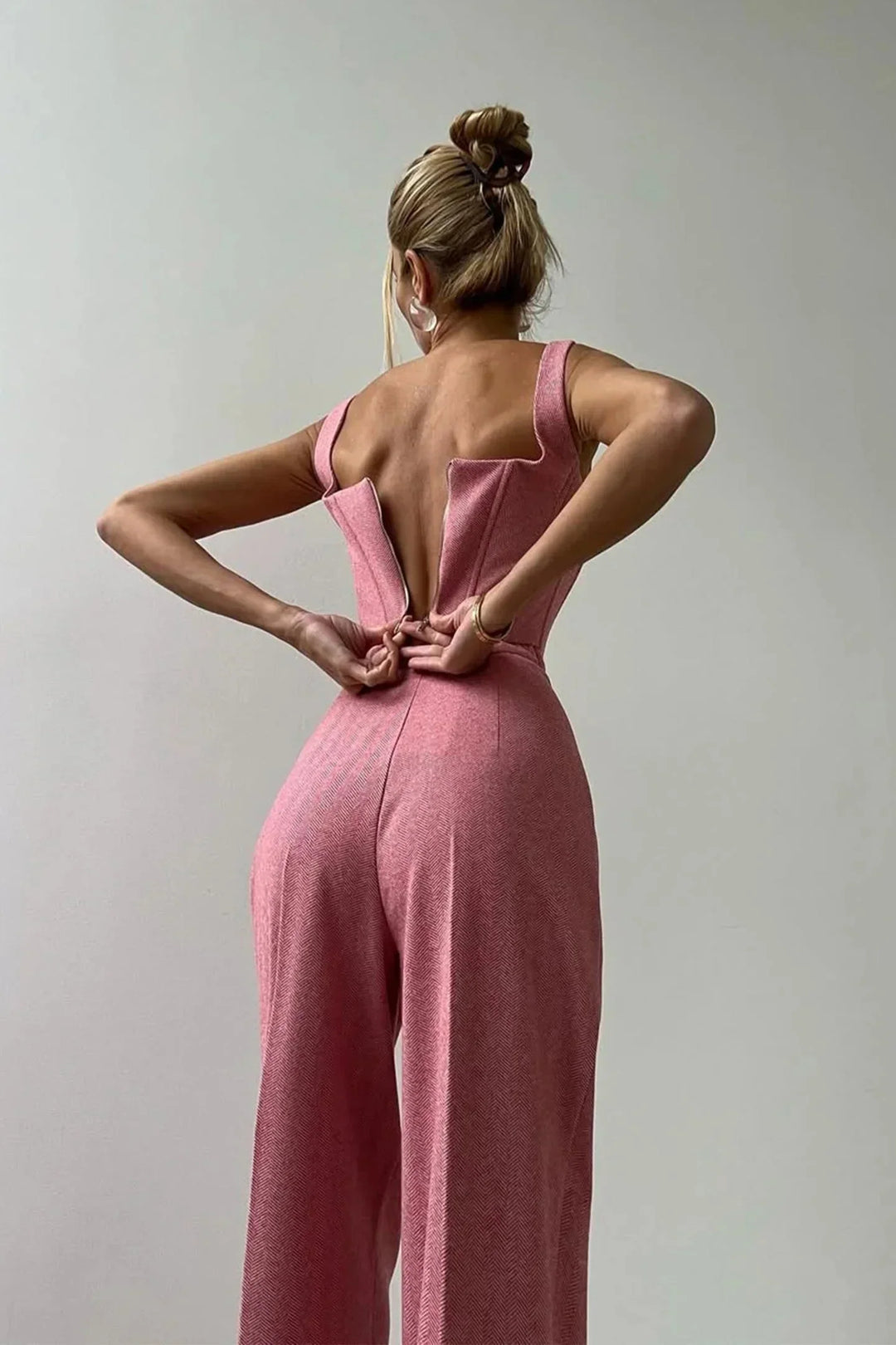 Woman wearing an elegant 3-piece power suit: corset, wide leg pants & oversized blazer for fashion.