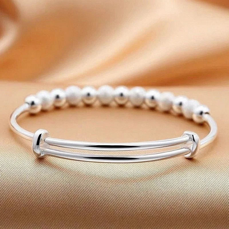 Stylish women's 925 silver charm bracelet, elegantly worn on a wrist, ideal for parties & gifts.