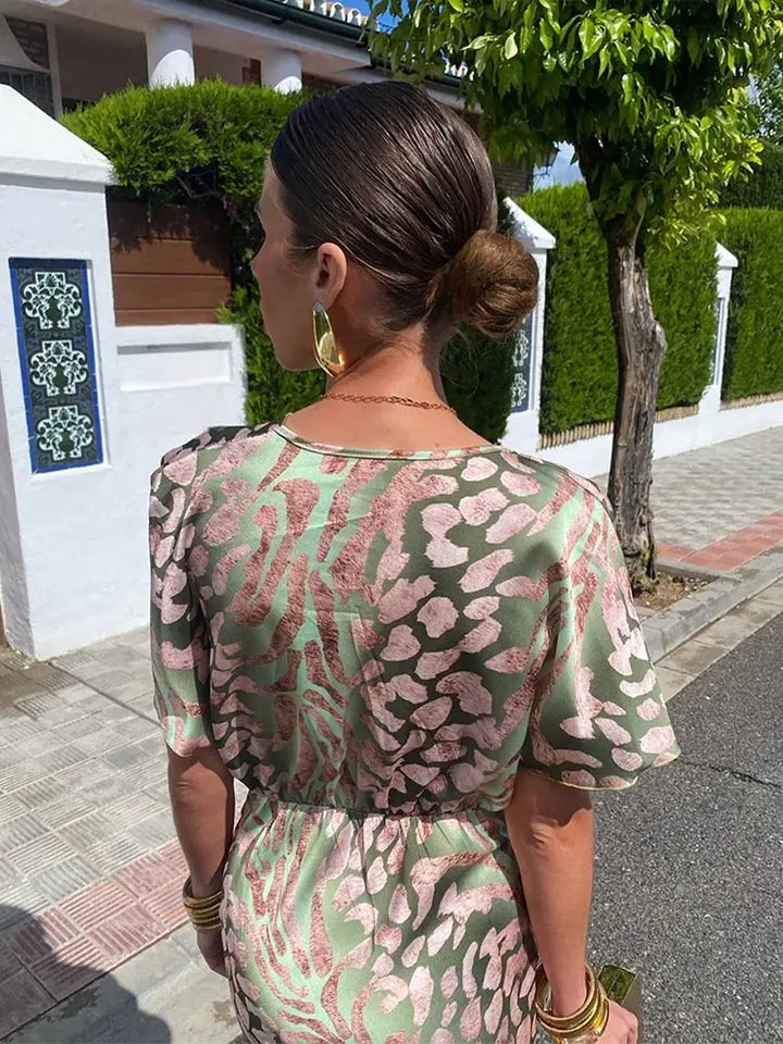 Stylish women's printed wrap midi dress with abstract pattern, ideal for elegant summer events.
