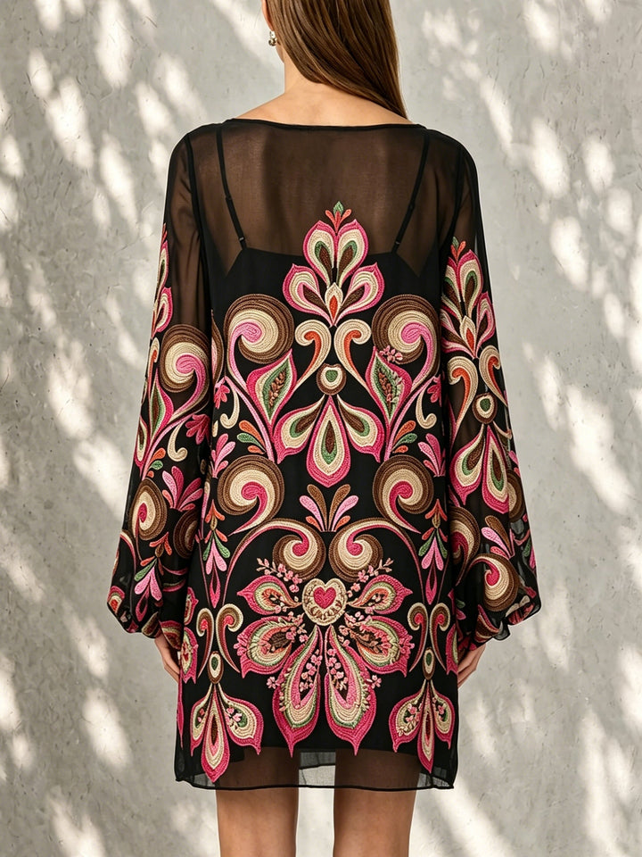 Close-up of elegant black floral mini dress fabric with sheer balloon sleeves & delicate boat neckline.
