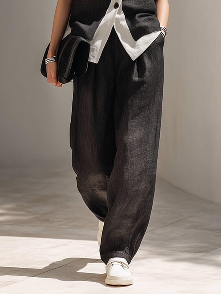 Tailored black two-piece outfit for women, including a smart vest & flowing wide-leg pants. Versatile for work or events.