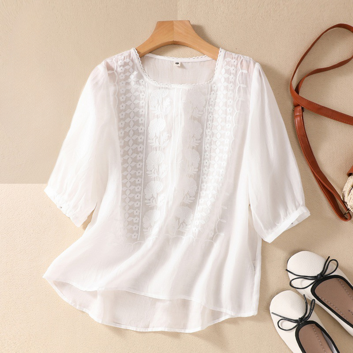 Women's elegant blouse with delicate floral lace details, perfect for summer fashion.