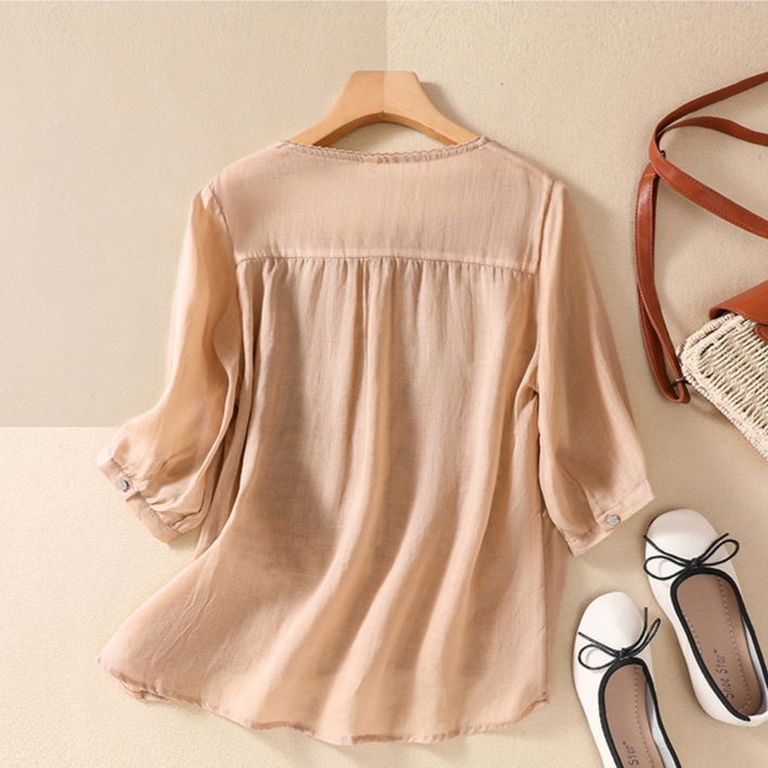 Women's elegant blouse with intricate floral lace details on short sleeves, perfect for summer fashion.