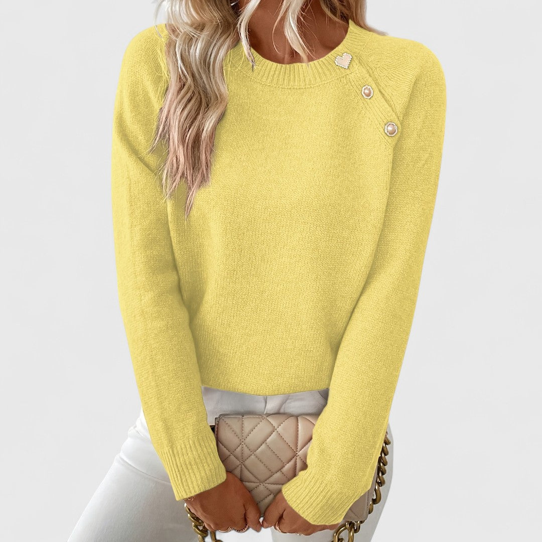 Sophisticated women's pullover sweater with crew neck and elegant pearl shoulder embellishment. A stylish top.