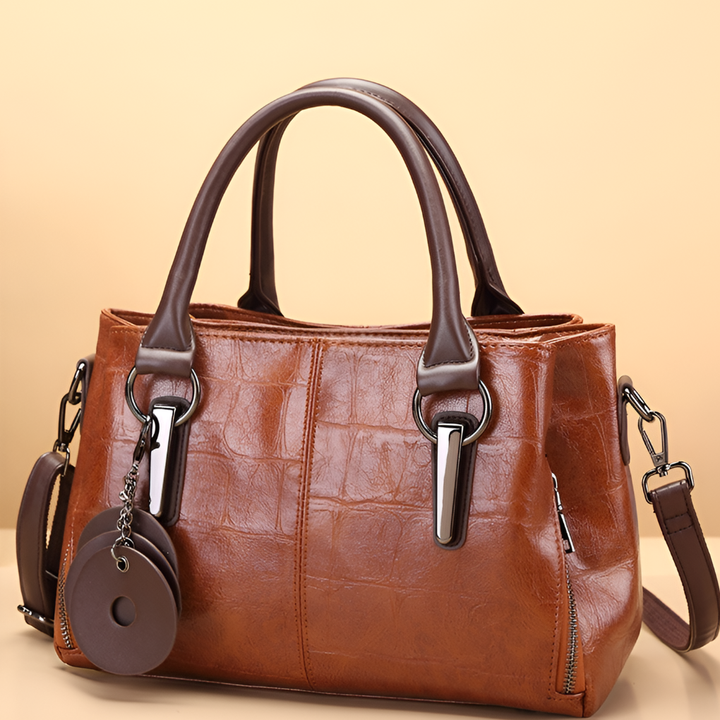 Women's elegant croc embossed Boston handbag. Features a chic shoulder strap and sturdy top handle for versatility.