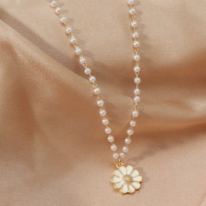 Classic style women's pearl necklace featuring a charming daisy pendant, elegant nature-inspired delicate jewelry.
