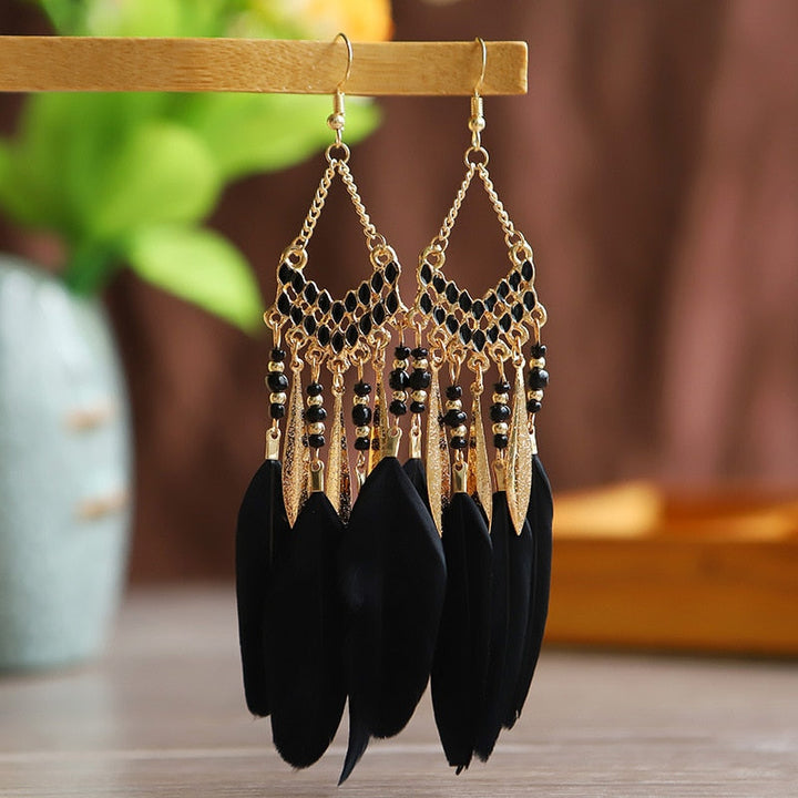 Delicate feather dangle earrings, gold plated and hypoallergenic. Elegant women's fashion jewelry.
