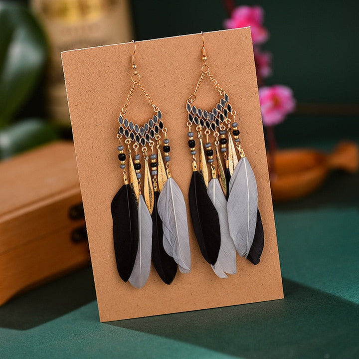 Long gold plated feather dangle earrings for women. Hypoallergenic and designed for elegant, boho-chic styles.
