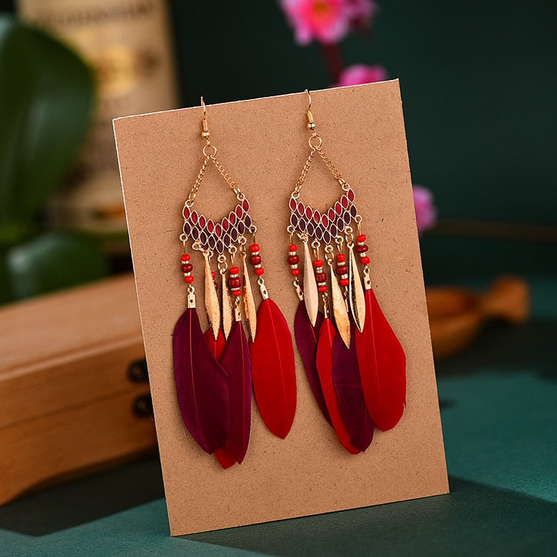 Stunning women's feather dangle earrings, embodying bohemian elegance. Gold plated, perfect statement jewelry.