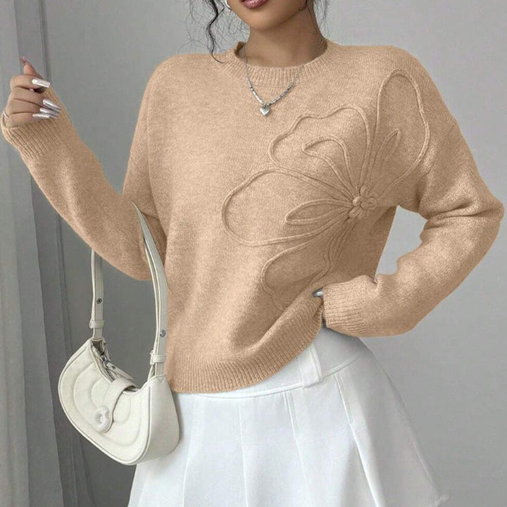 Close-up of a women's elegant floral knit sweater, featuring delicate flower patterns on a comfortable pullover.